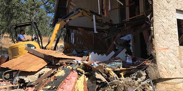 An excavator demolishing an old building.